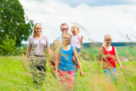 Eltern mit drei Kindern bei Ausflug in der Natur